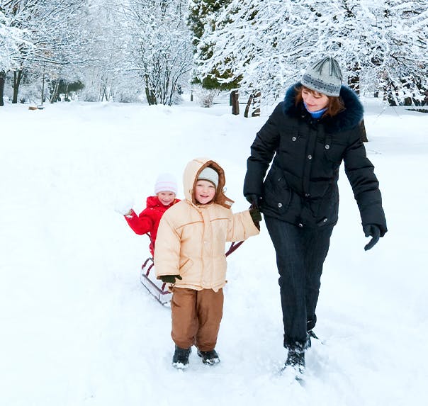 Une femme et un homme souriants sont assis dehors en plein hiver