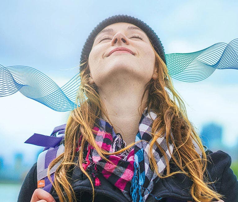 Une femme inspire profondément de l’air frais