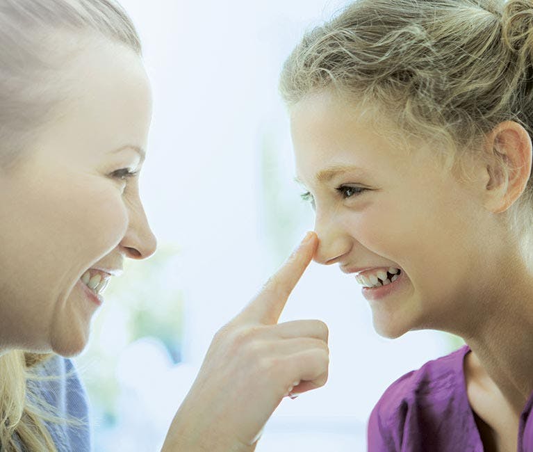 After using baby cold remedies, woman touching her daughter’s unblocked nose