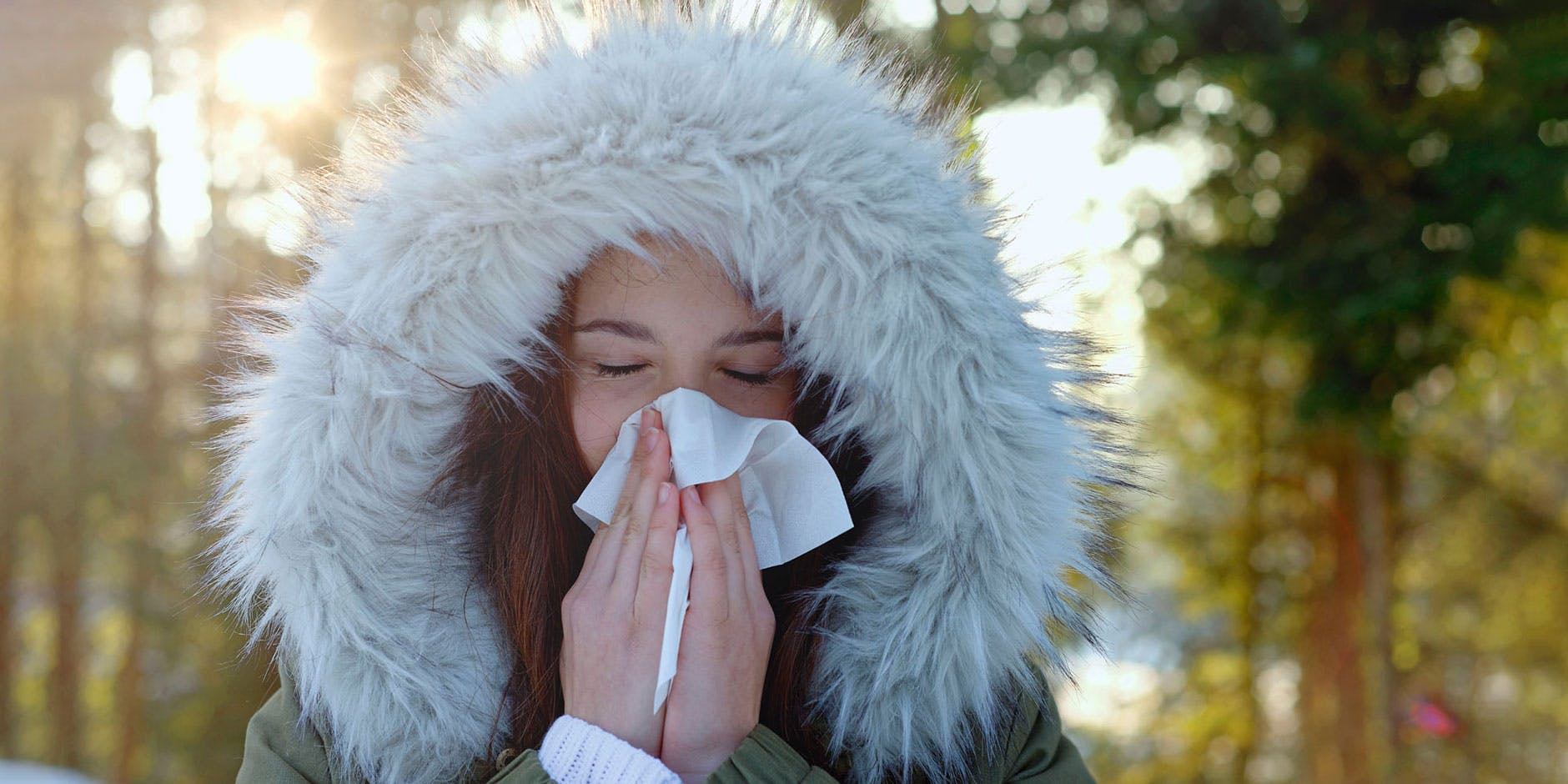 Frau putzt ihre verstopfte Nase in der kalten Winterluft.