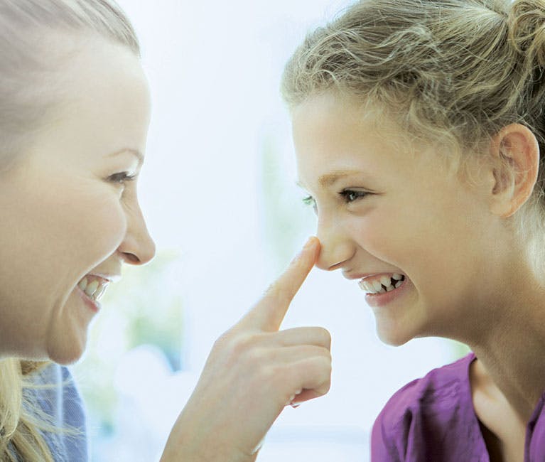 Eine Mutter berührt die Nase ihrer Tochter