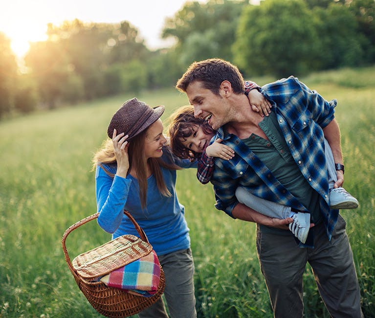 Eine junge Familie ohne Heuschnupfen genießt die Natur dank der Hilfe von Otri Allergie Nasenspray.