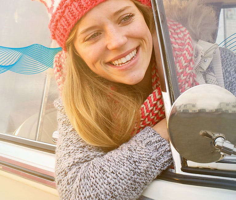 Grippe oder Erkältung: Frau lässt sich im offenen Autofenster den Fahrtwind um die Nase wehen