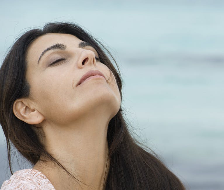 Woman with clear sinuses lifts head to breath in fresh air