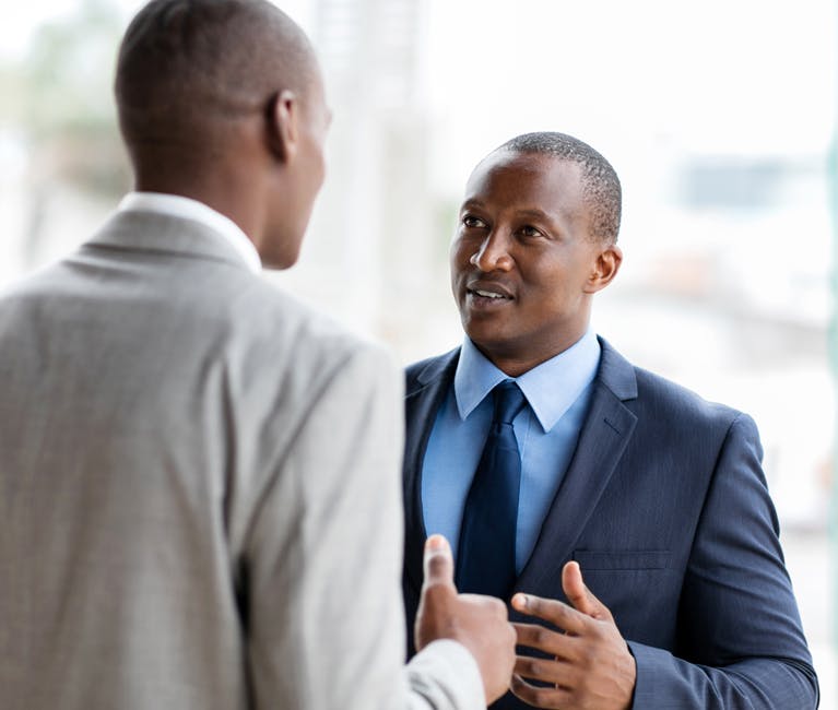 Two healthy men talking in office space