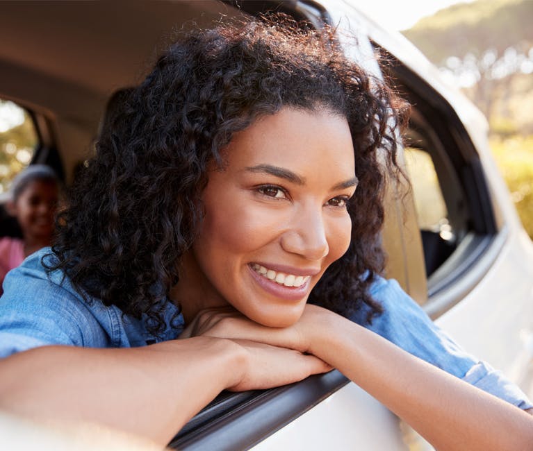 Woman enjoying being free from a cold, blocked nose and hay fever in a car with the window open