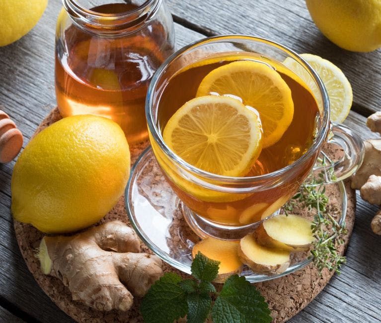 A cup of tea with honey, lemon and fresh ginger, a great drink to help get rid of cold or flu symptoms fast.