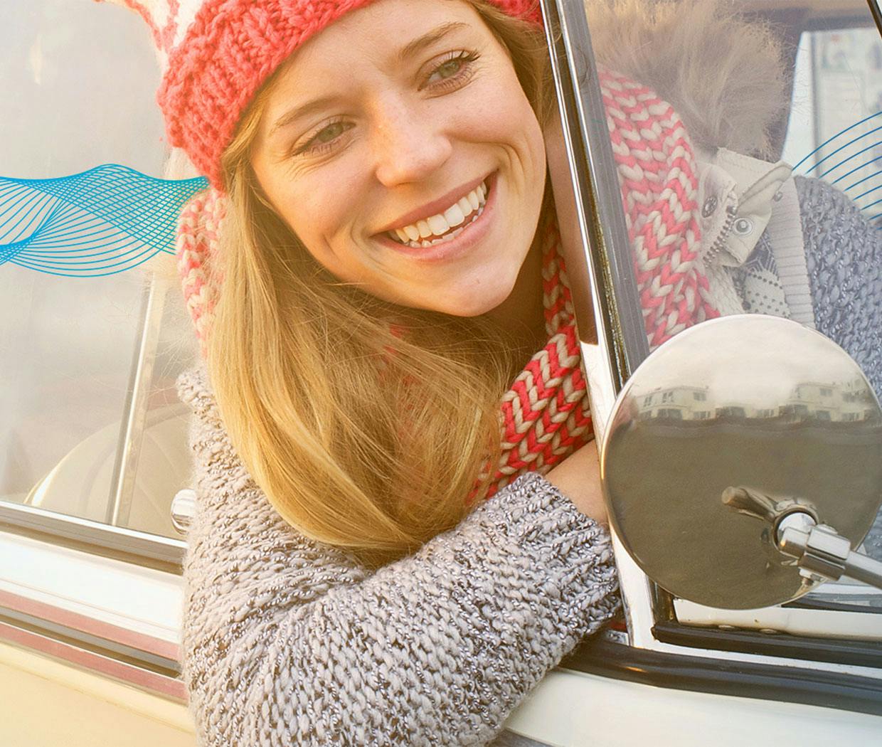 Nő mosolyog autó ablakán kihajolva