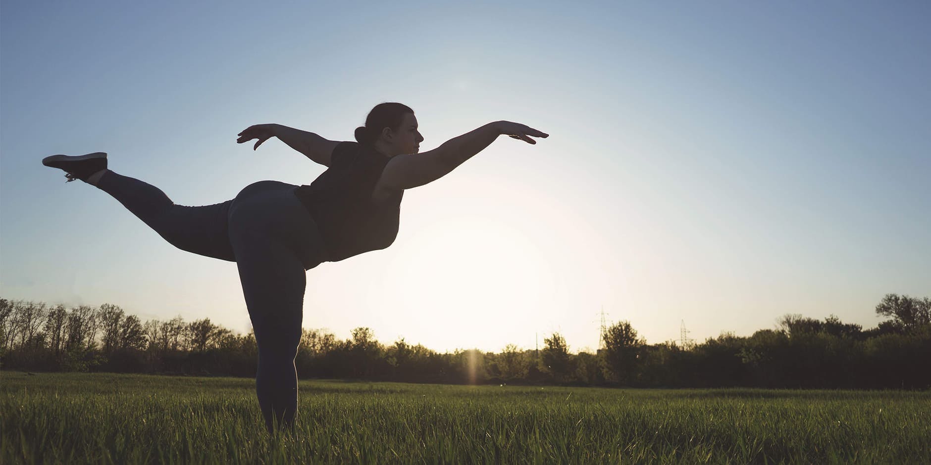 Naplementében jógázó nő