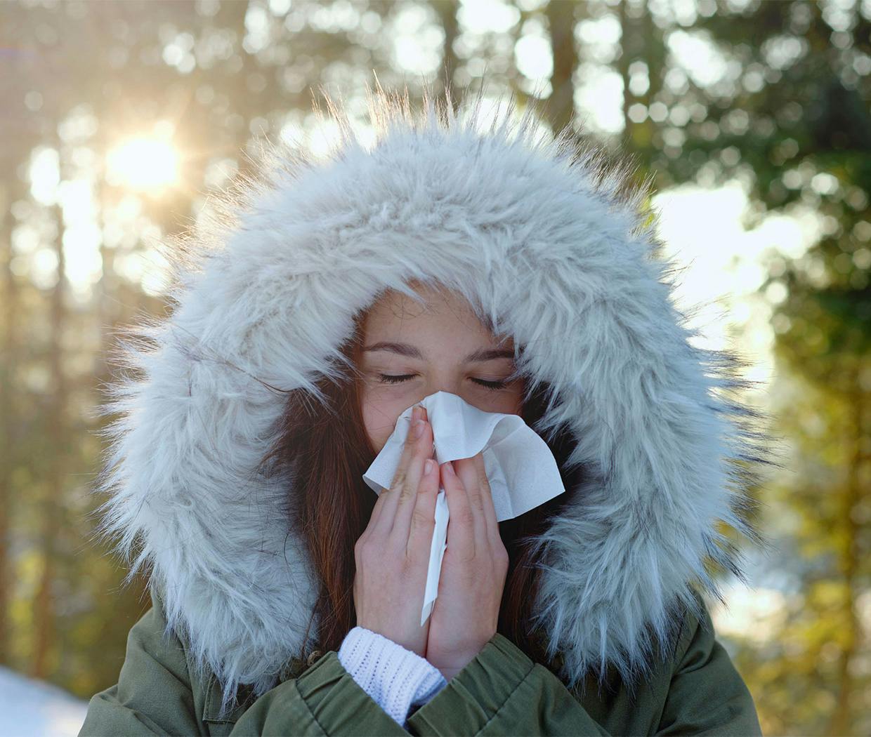Sieviete aukstā ziemas gaisā šņauc savu aizlikto degunu
