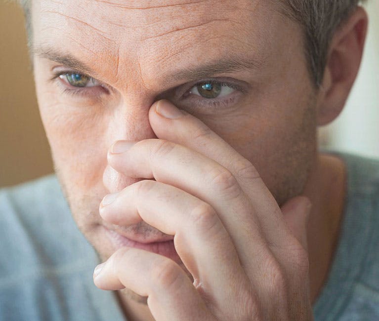 149320835 Man suffering nasal congestion massages his sinuses