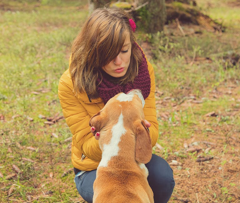 Femeie care se joacă cu un câine în parc