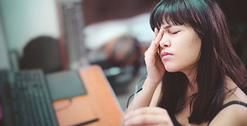 Woman having migraine at work
