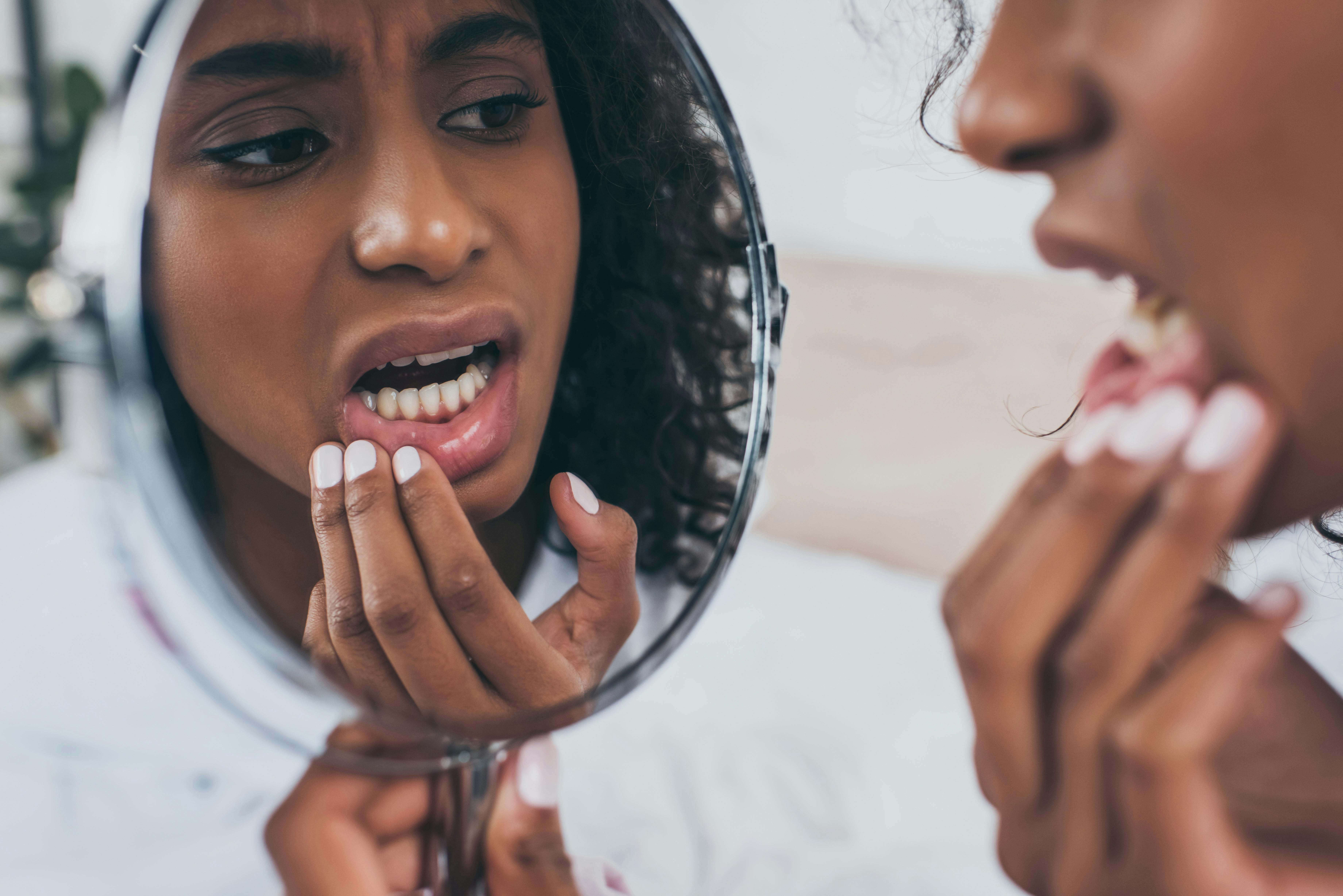 Woman looking at teeth in mirror