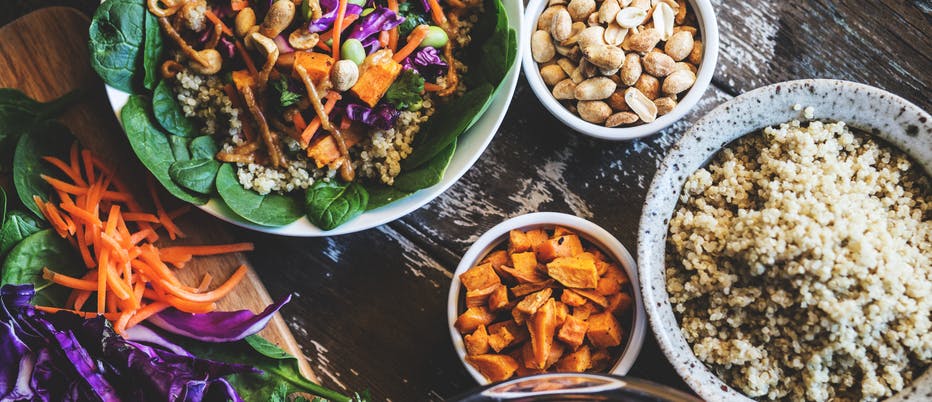 A table with bowls of vegetables and whole grains