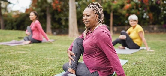 Women doing outdoor yoga in a park