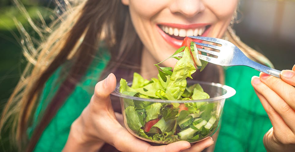 Woman eating low fodmap salad Woman eating low fodmap salad