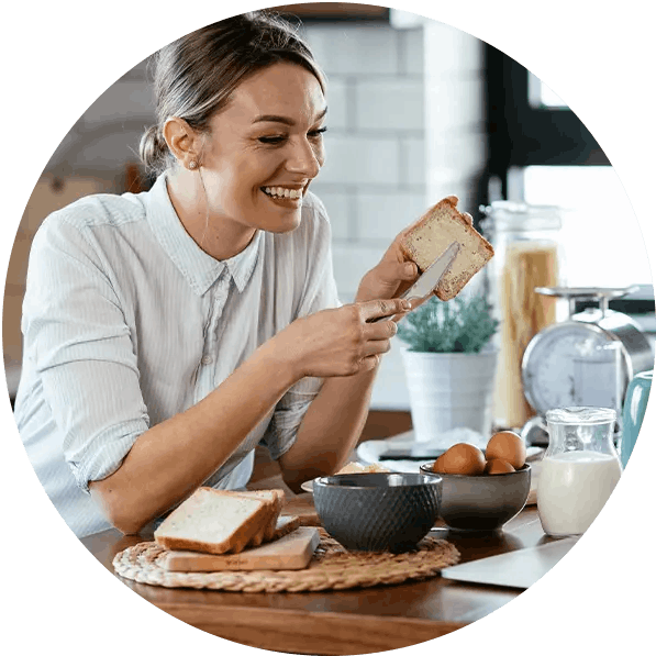 Smiling woman eating toast in kitchen