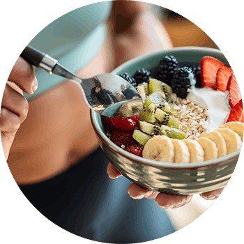 Woman eating a bowl of fruit and oatmeal