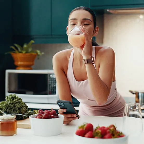 Woman making smoothie with prebiotics and probiotics for digestive gut health