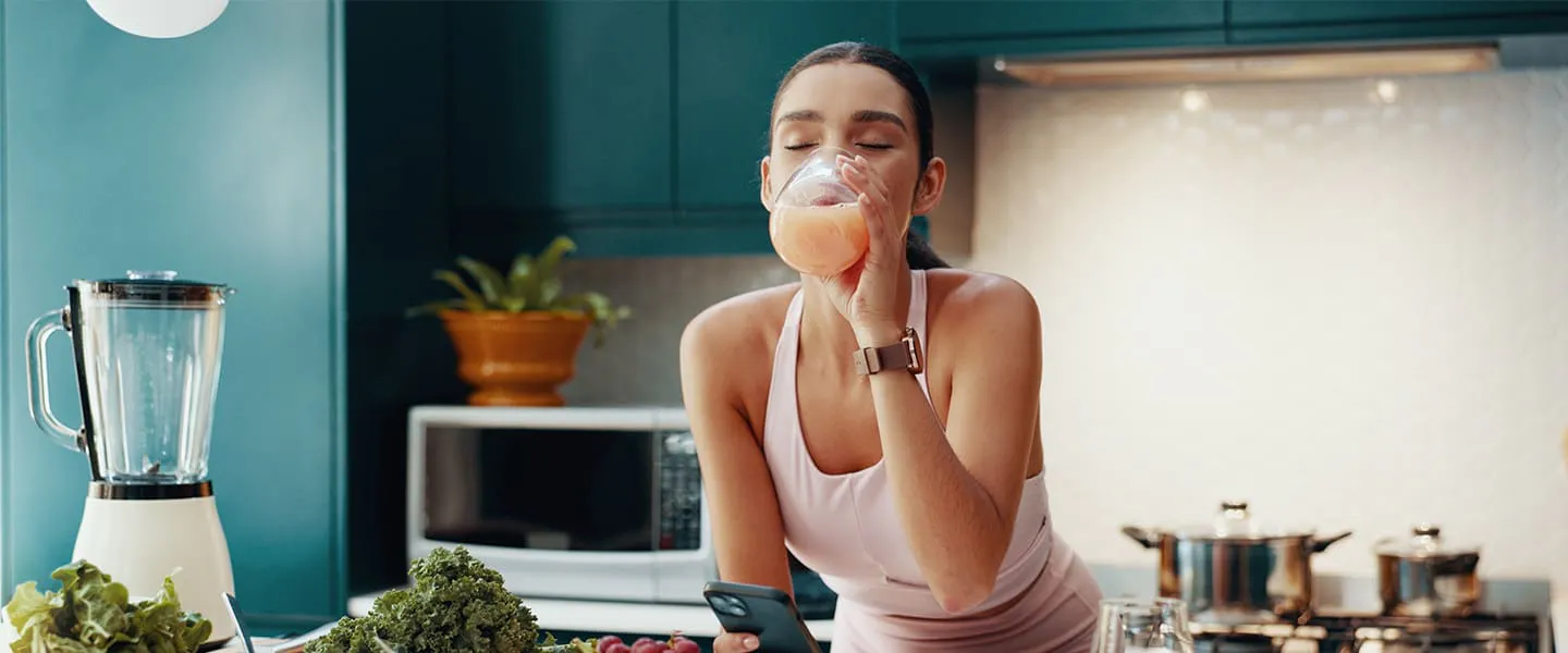 Woman making smoothie with prebiotics and probiotics for digestive gut health
