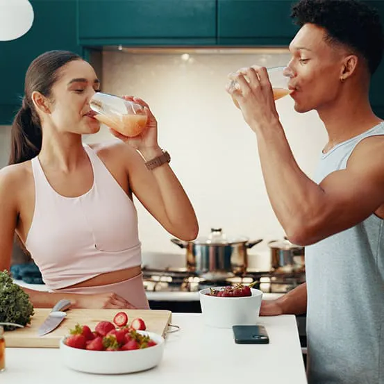 Man and woman drinking juice and eating a gut-friendly breakfast