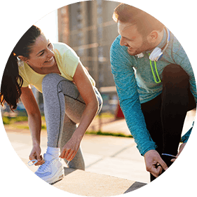 Man and woman in running gear tying shoe laces