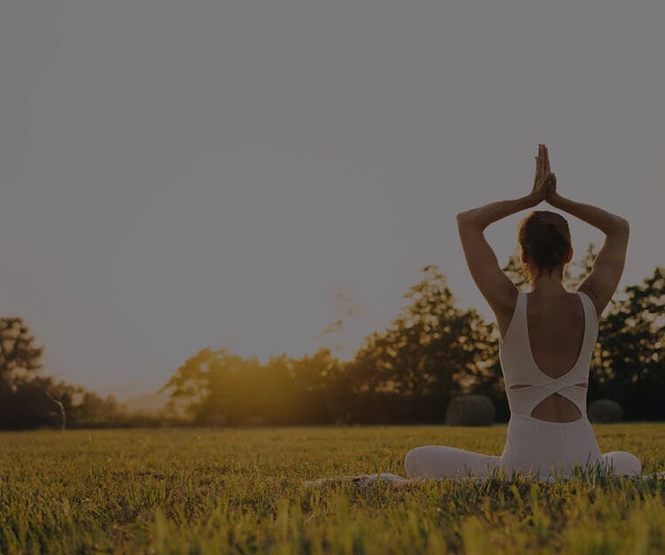 Femme réalisant une posture de yoga à l’extérieur