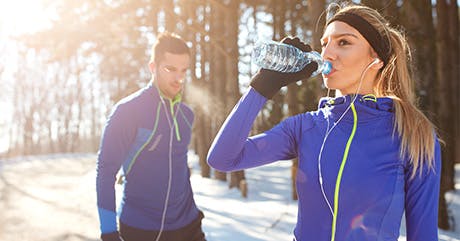 Woman with man drinking water on winter day