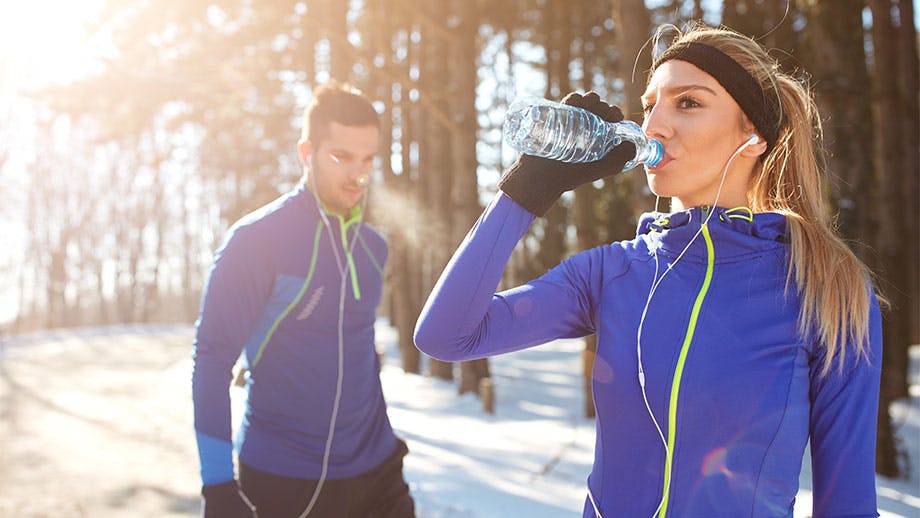 Woman with man drinking water on winter day Woman with man drinking water on winter day