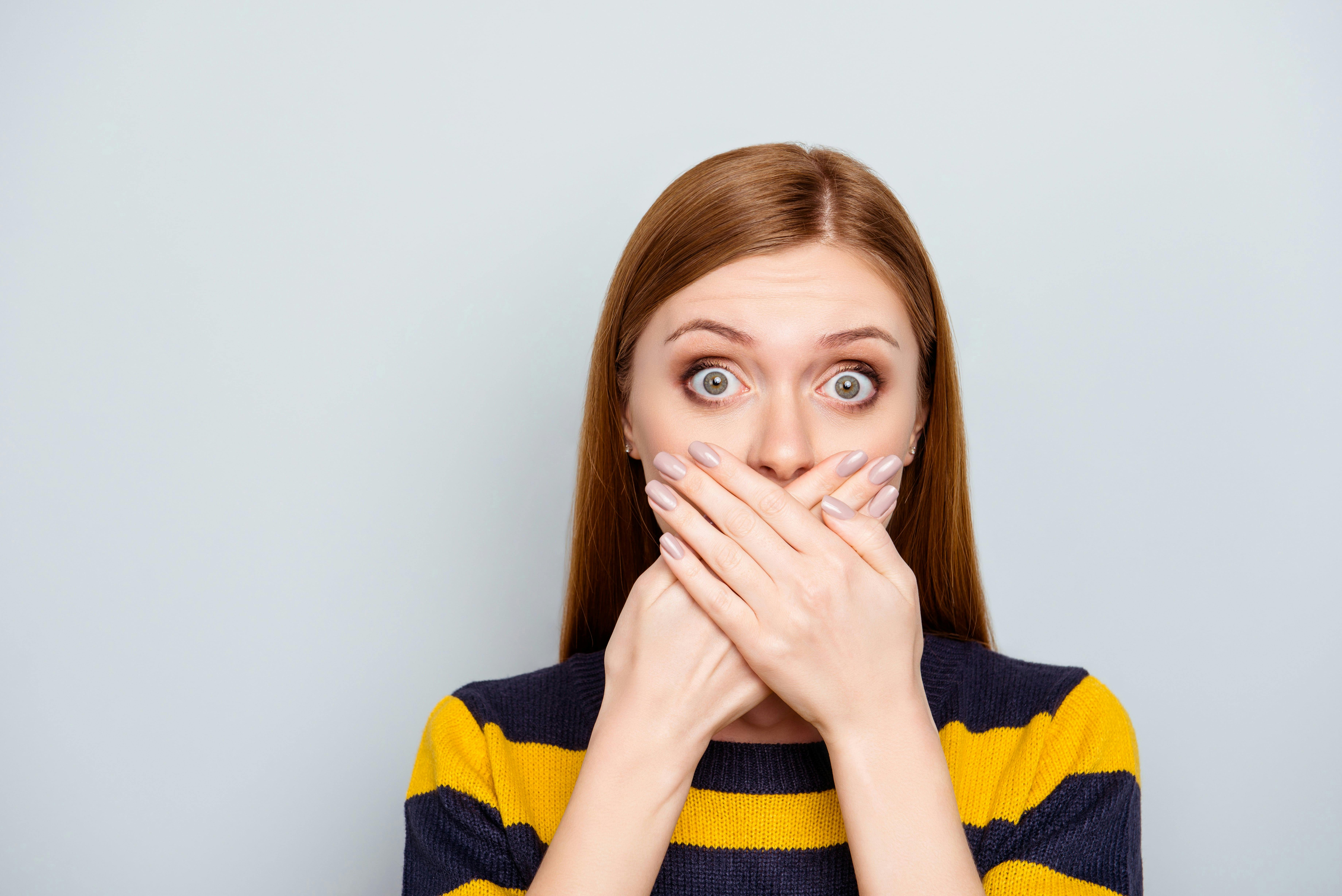 Woman crossing hands over mouth in shock