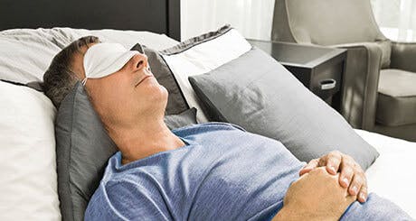 Man sleeping with a sleep mask on