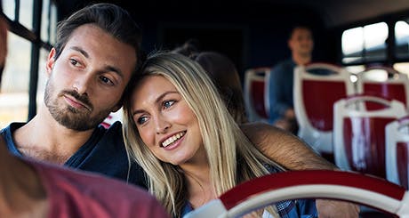 Jeune couple voyageant ensemble en autobus.