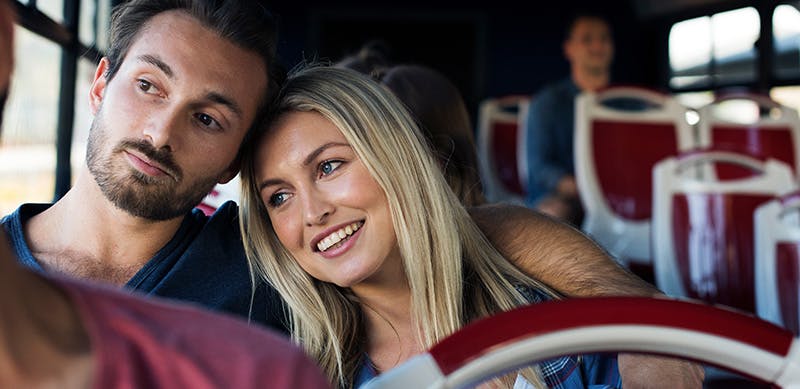 Jeune couple voyageant ensemble en autobus.