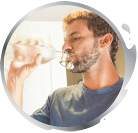 Homme buvant de l'eau en bouteille