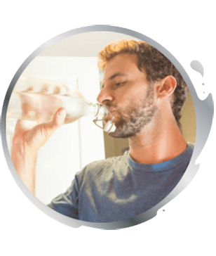 man drinking a glass of iced water