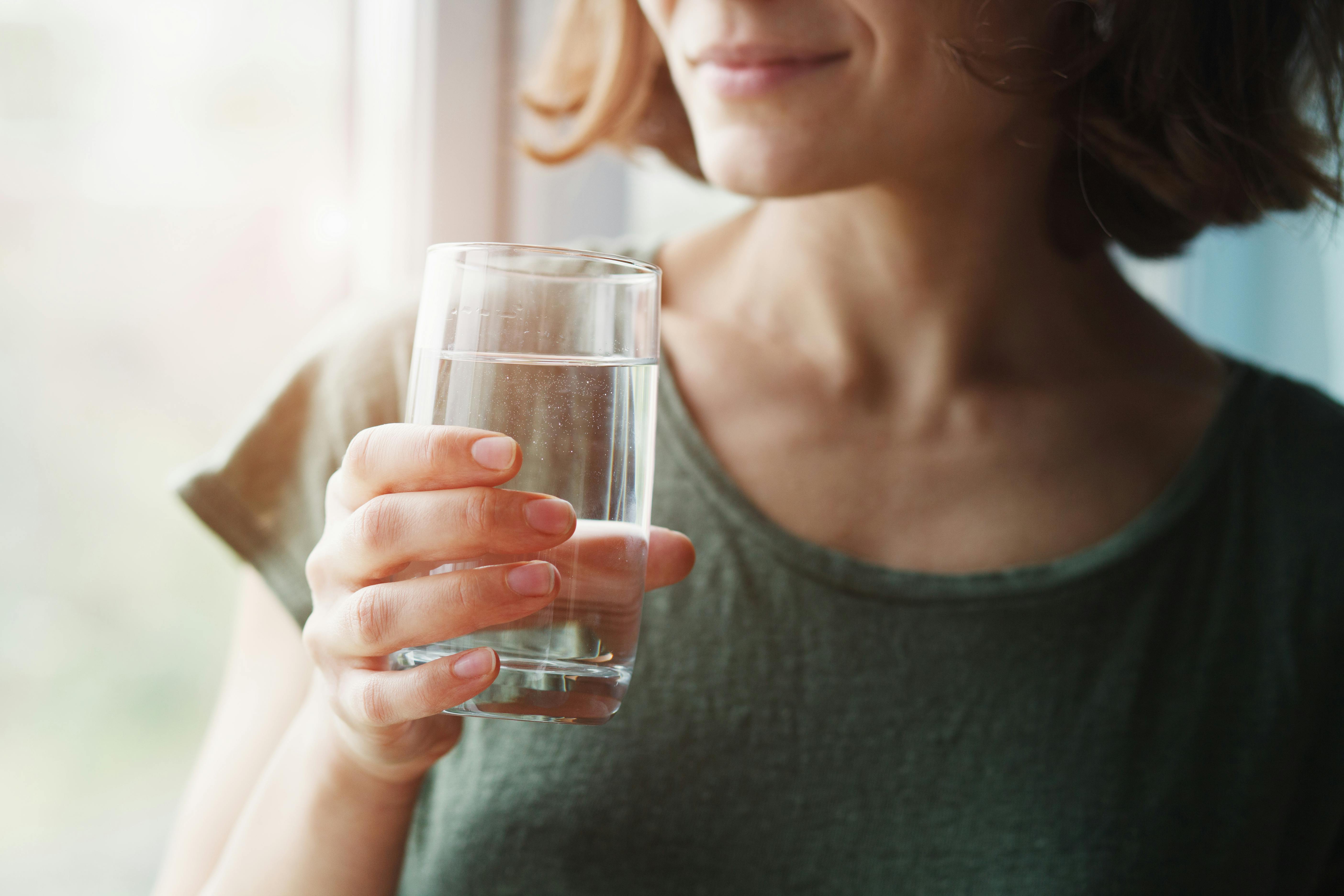 Woman drinking water to help dry mouth