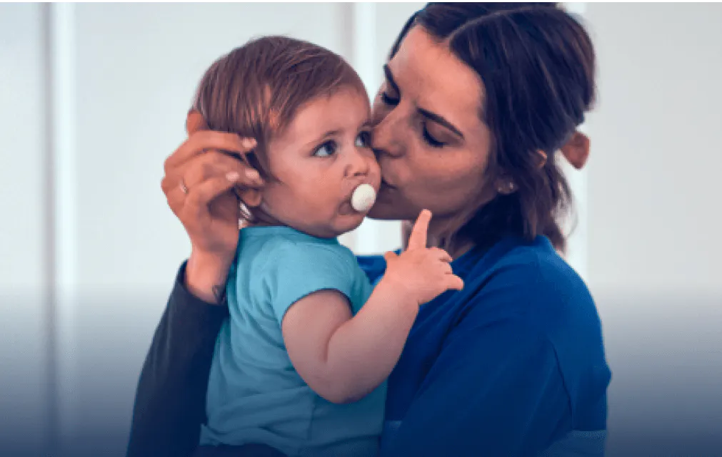 Mother holding and kissing the baby