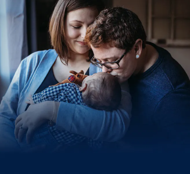 Family kissing an infant
