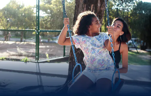 Mother pushes child on a swing