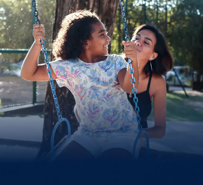 Mother pushes child on a swing