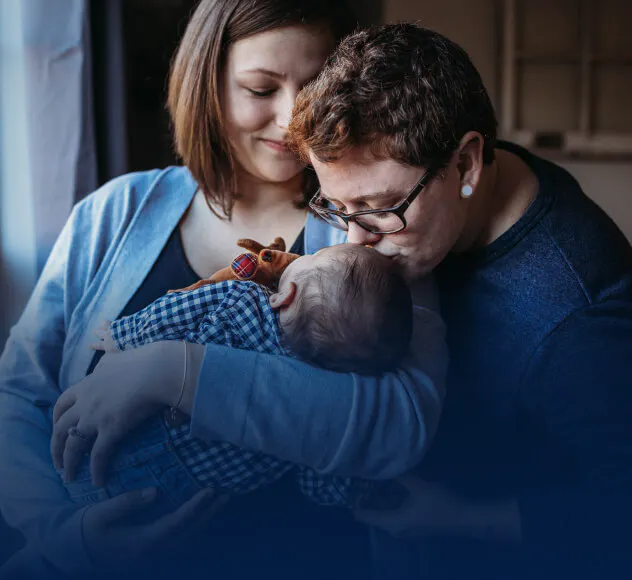 Family kissing an infant