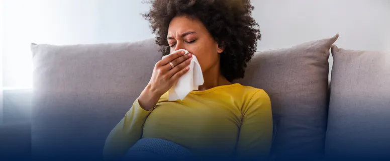 Woman sitting on a couch with tissue