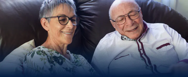 An elderly couple looking at a tablet