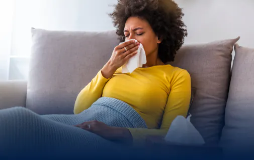 Woman sitting on couch with tissue