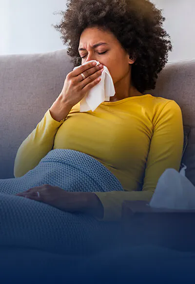 Woman sitting on couch with tissue
