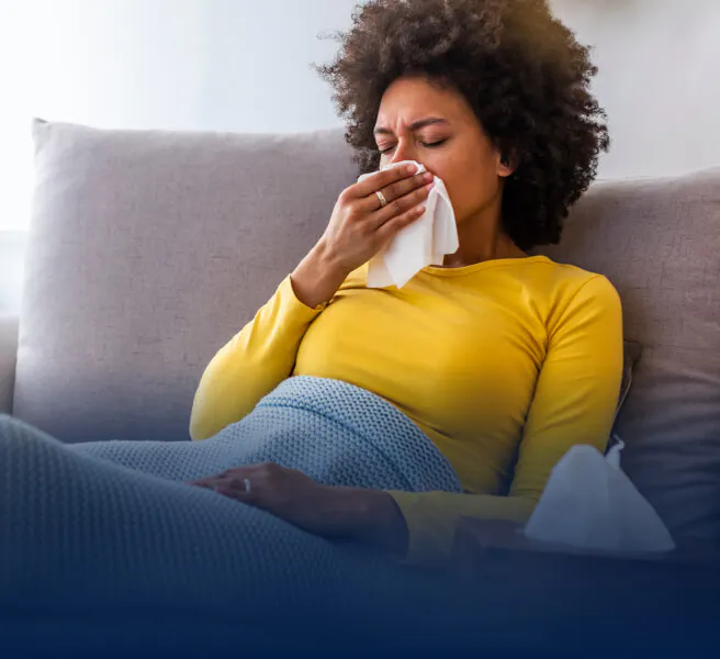 Woman sitting on couch with tissue
