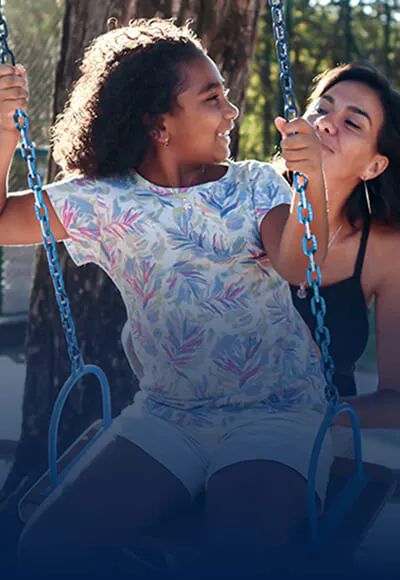 Mother pushes child on a swing