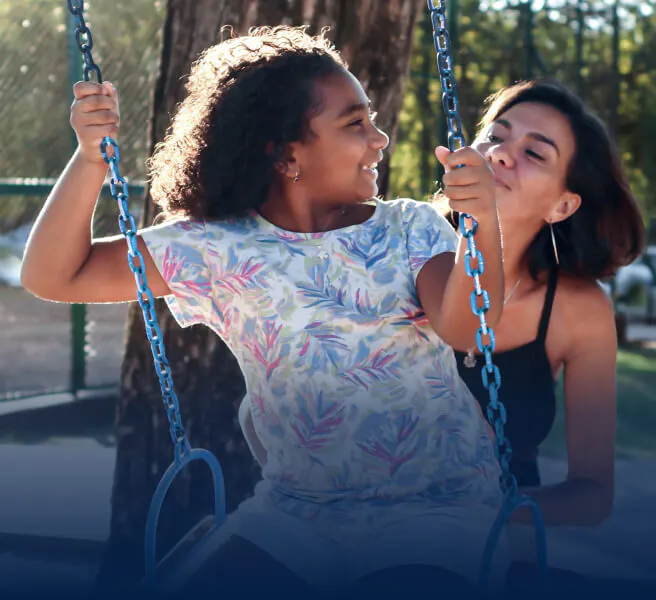 Mother pushes child on a swing