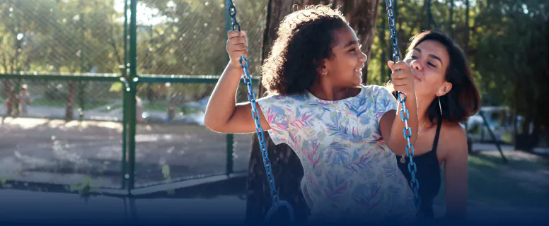 Mother pushes child on a swing